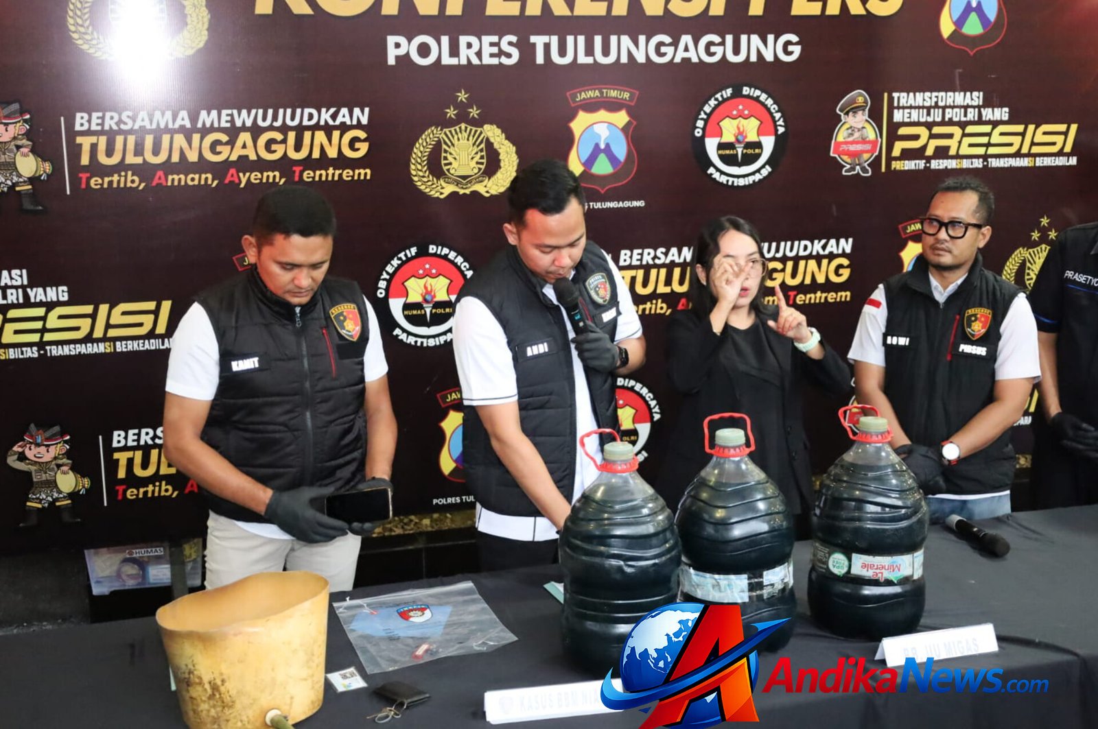Petugas Satreskrim Polres Tulungagung menampilkan barang bukti berupa galon berisi Pertalite, selang, ember modifikasi, serta mobil yang digunakan pelaku dalam kasus penyalahgunaan BBM subsidi di Tulungagung.